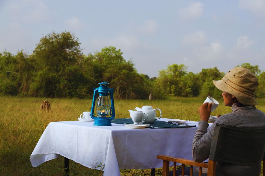A guest is relaxing at big game camps Wilpattu campsite after the evening safari